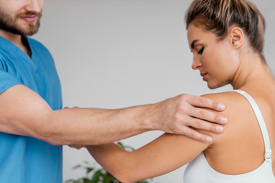 Specialist examines shoulder pain in patient