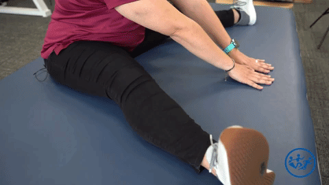 Physical therapist demonstrates the added lumbar flexion, a great pregnancy exercise for pelvic health.