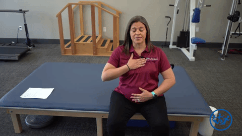 Physical therapist demonstrates diaphragmatic breathing, a great pregnancy exercise for pelvic health.