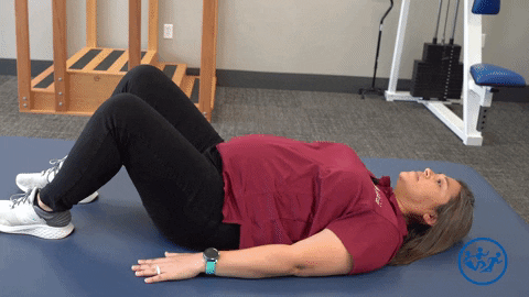Physical therapist demonstrates a bridge stretch, a great pregnancy exercise for pelvic health.
