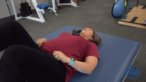 Physical therapist demonstrates a piriformis stretch, a great pregnancy exercise for pelvic health.