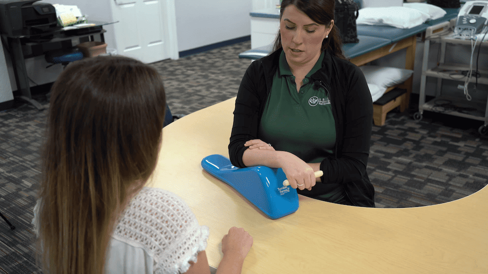 Rachel Colman, OTR/L Occupational Therapist, Ability Rehabilitation. Demonstrating hand and arm occupational therapy tool